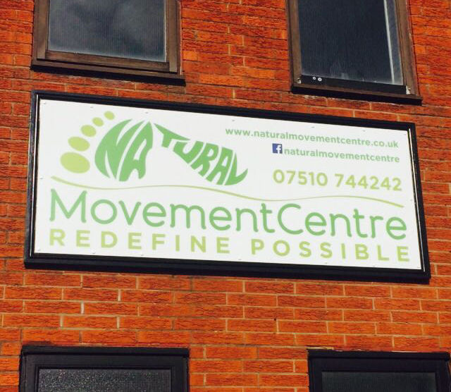 Printed business signage installed on a brick building